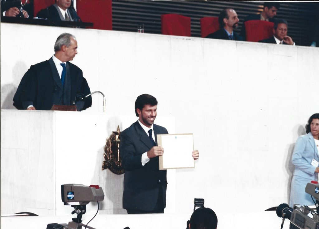 Carlos Sampaio segurando diploma em cerimônia oficial em plenário